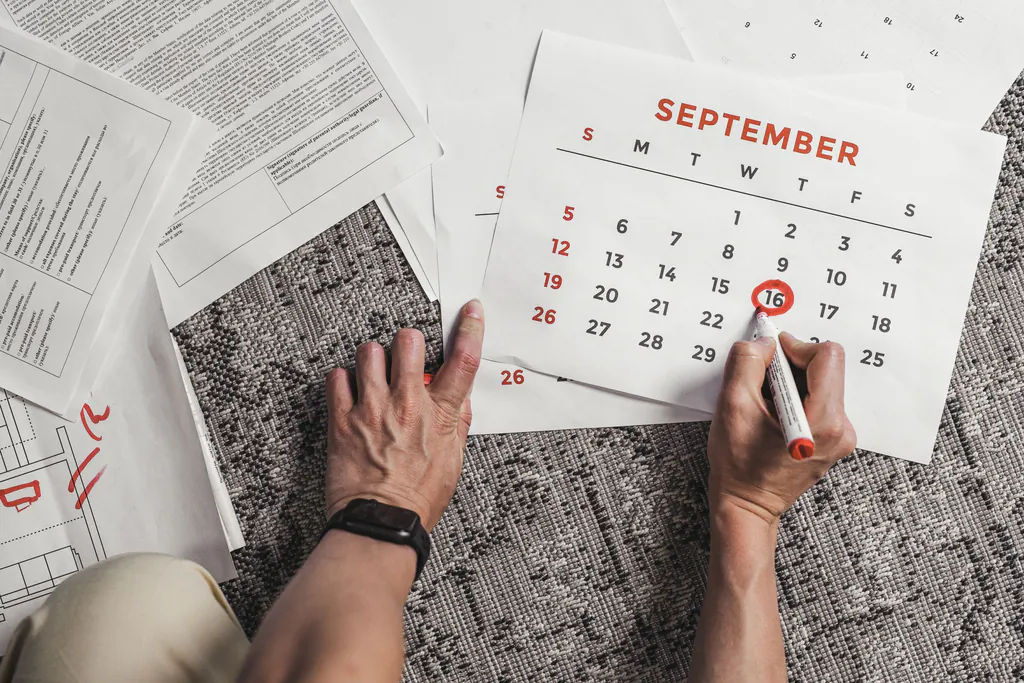Hands circle a date on a paper calendar in red marker, surrounded by paperwork, a renewal date that is easy to miss